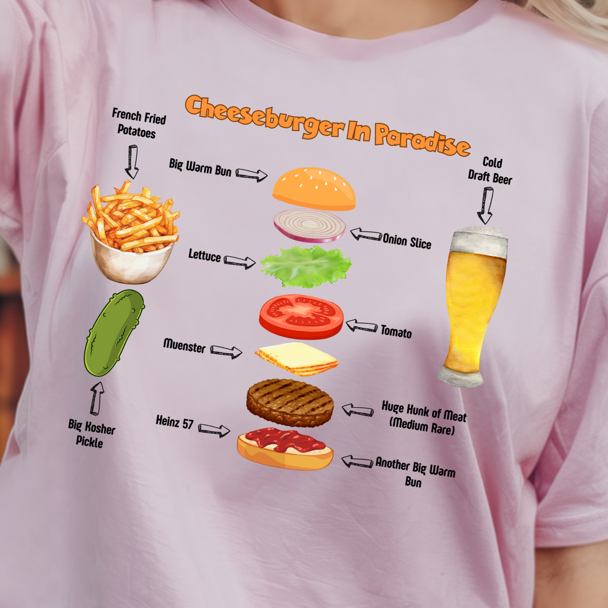 A woman wearing a light pink graphic t-shirt with a colorful cheeseburger in paradise food travel-style diagram printed on the front.